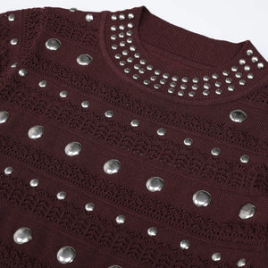 Maroon sweater with silver studded details on a white background
