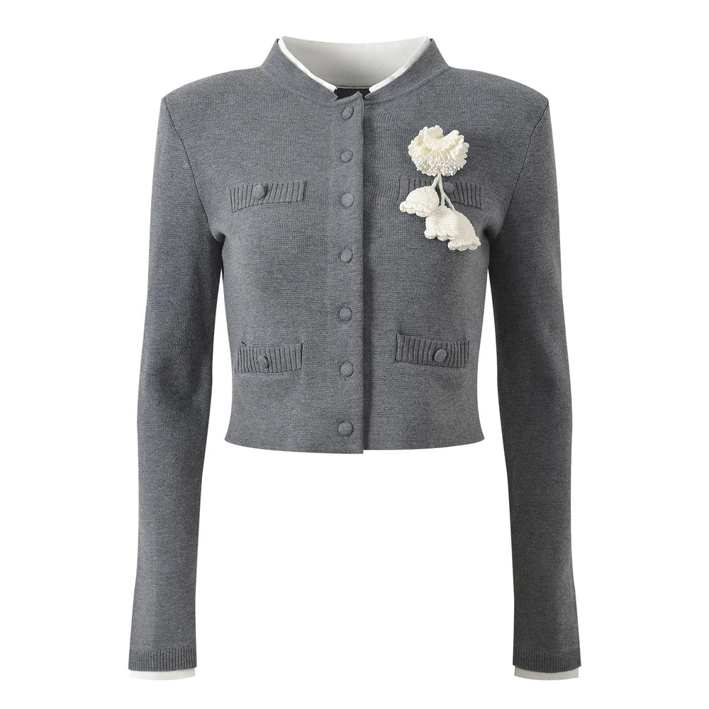 Gray cardigan with white floral brooch on a white background