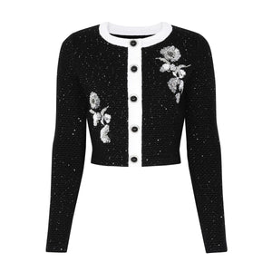 Black cardigan with floral embroidery on a white background