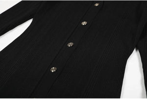 Close-up of a black ribbed sweater with buttons on a white background