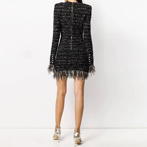 Black tweed dress with fringe details on a white background