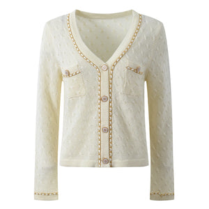 Cream-colored cardigan with button details on a white background