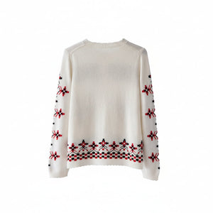 White sweater with red and black pattern on a wooden hanger against a white background