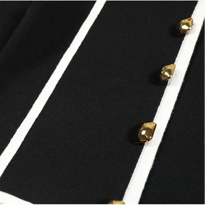 Close-up of a black garment with gold buttons on a white background