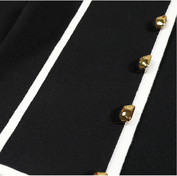 Close-up of a black garment with gold buttons on a white background
