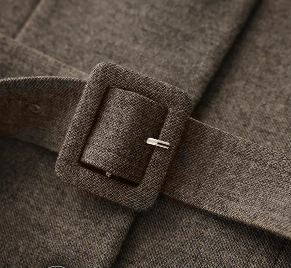 Close-up of a brown belt with a buckle on a textured fabric background