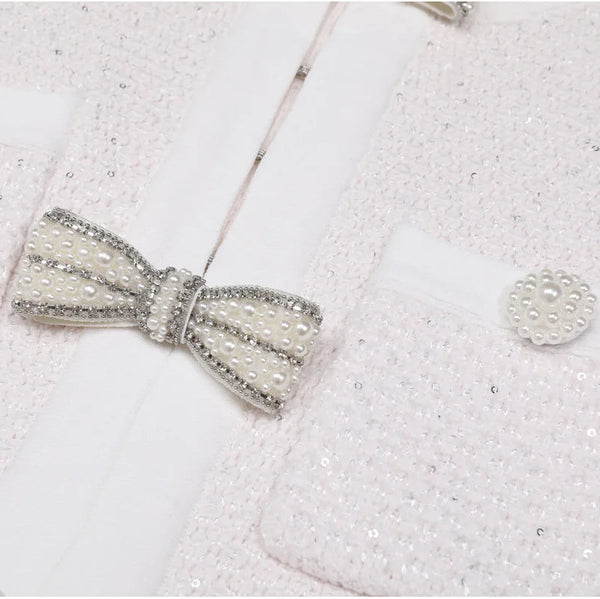 Silver bow tie and cufflinks on a textured white surface