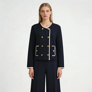 Woman wearing a navy blue suit with gold buttons on a white background