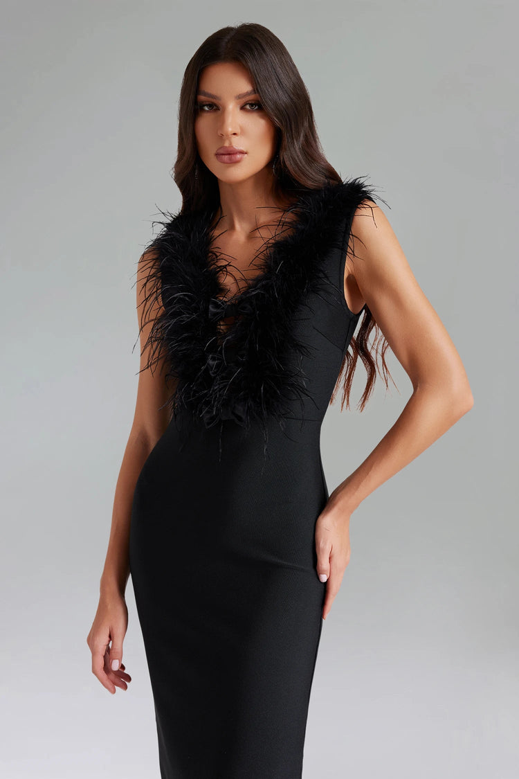 Woman wearing a black dress with feathered details on a gray background