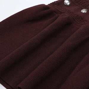 Close-up of a brown ribbed sweater with decorative buttons on a white background