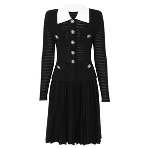 Black dress with white collar and decorative buttons on a white background