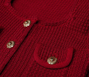 Close-up of a red knitted cardigan with gold buttons