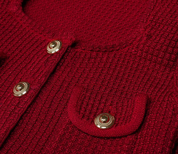 Close-up of a red knitted cardigan with gold buttons