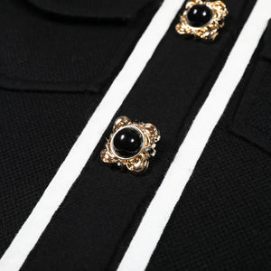 Black and gold buttons on a black and white striped fabric