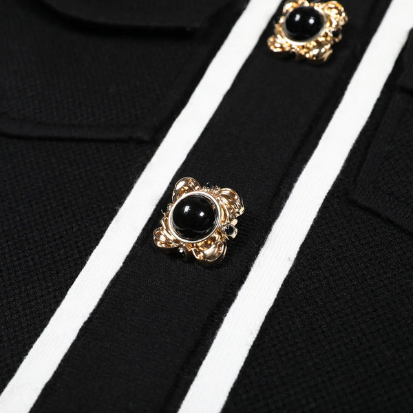 Black and gold buttons on a black and white striped fabric