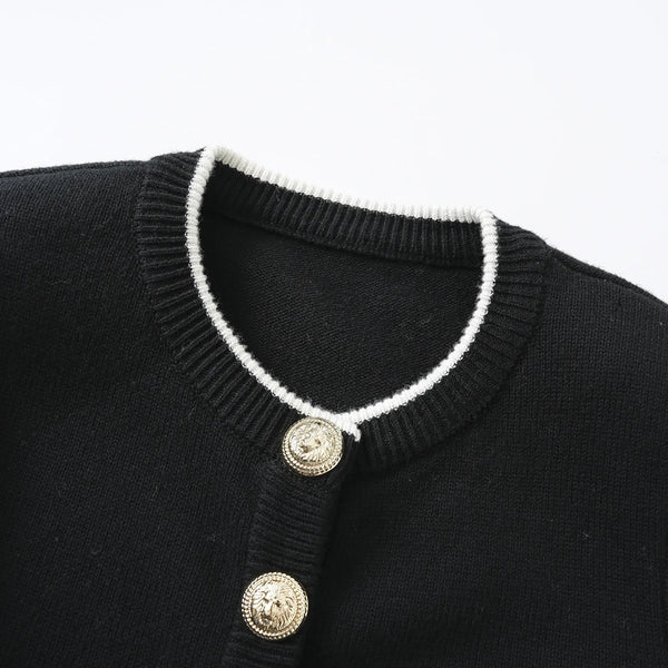 Black sweater with white trim and gold buttons on a white background
