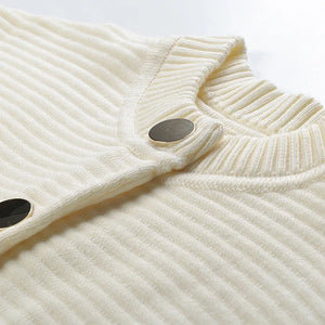 Close-up of a cream-colored ribbed sweater with button details on a white background