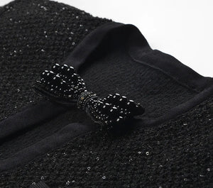 Black textured fabric with a decorative bow on a white background