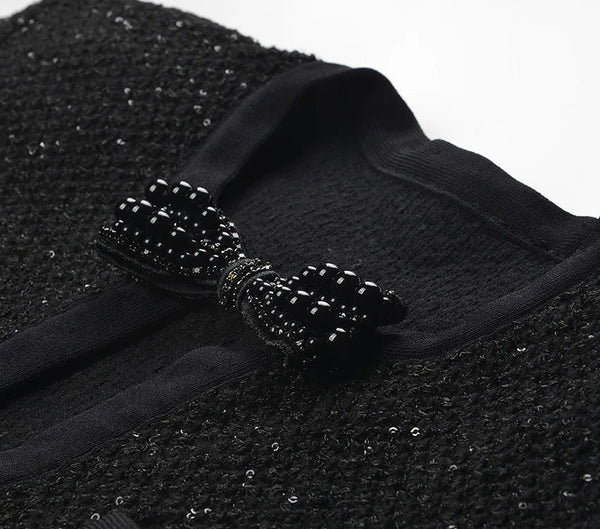 Black textured fabric with a decorative bow on a white background