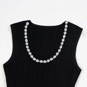 Black sleeveless top with a decorative silver necklace on a white background