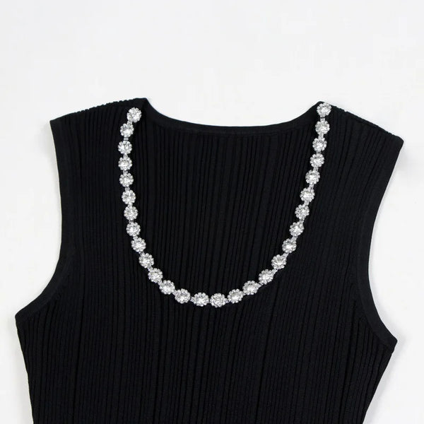 Black sleeveless top with a decorative silver necklace on a white background