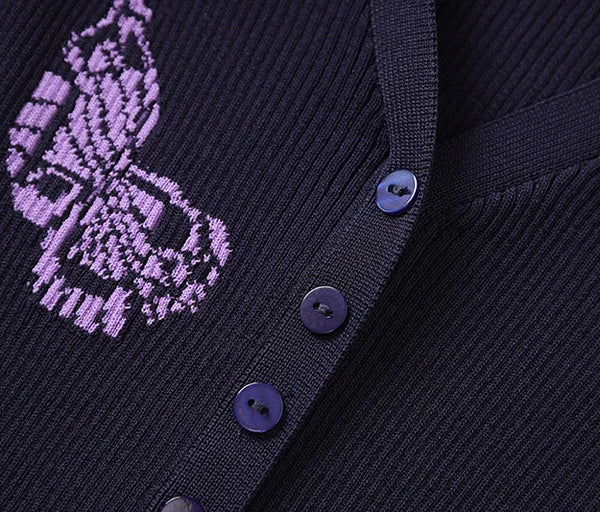 Close-up of a dark blue cardigan with purple embroidered design and buttons.