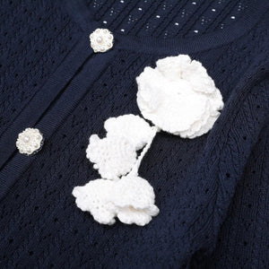 Navy blue textured fabric with white floral embellishments