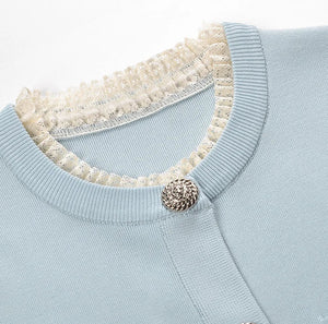 Light blue sweater with a textured collar and button detail on a white background