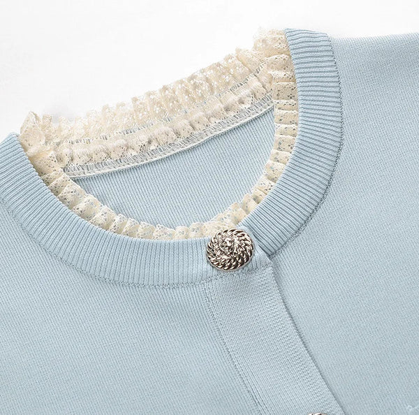 Light blue sweater with a textured collar and button detail on a white background