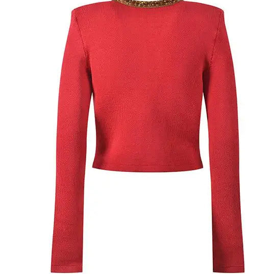 Red long-sleeve top with gold trim on a white background