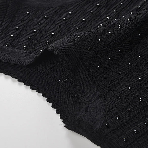 Black knit fabric with stud embellishments on a white background