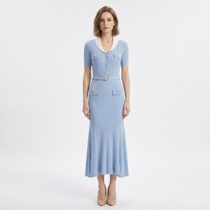 A light blue ribbed knit midi dress with short sleeves, a white collar, gold-tone buttons, and a matching belt with a decorative buckle, shown on a white background.