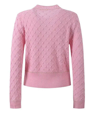 Pink sweater with a diamond pattern on a white background