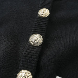 Close-up of a black garment with gold buttons