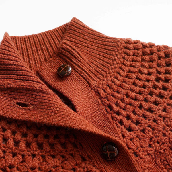 Close-up of a brown knitted sweater with buttons on a white background