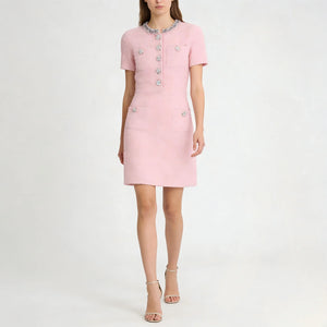 Pink dress with decorative buttons on a white background