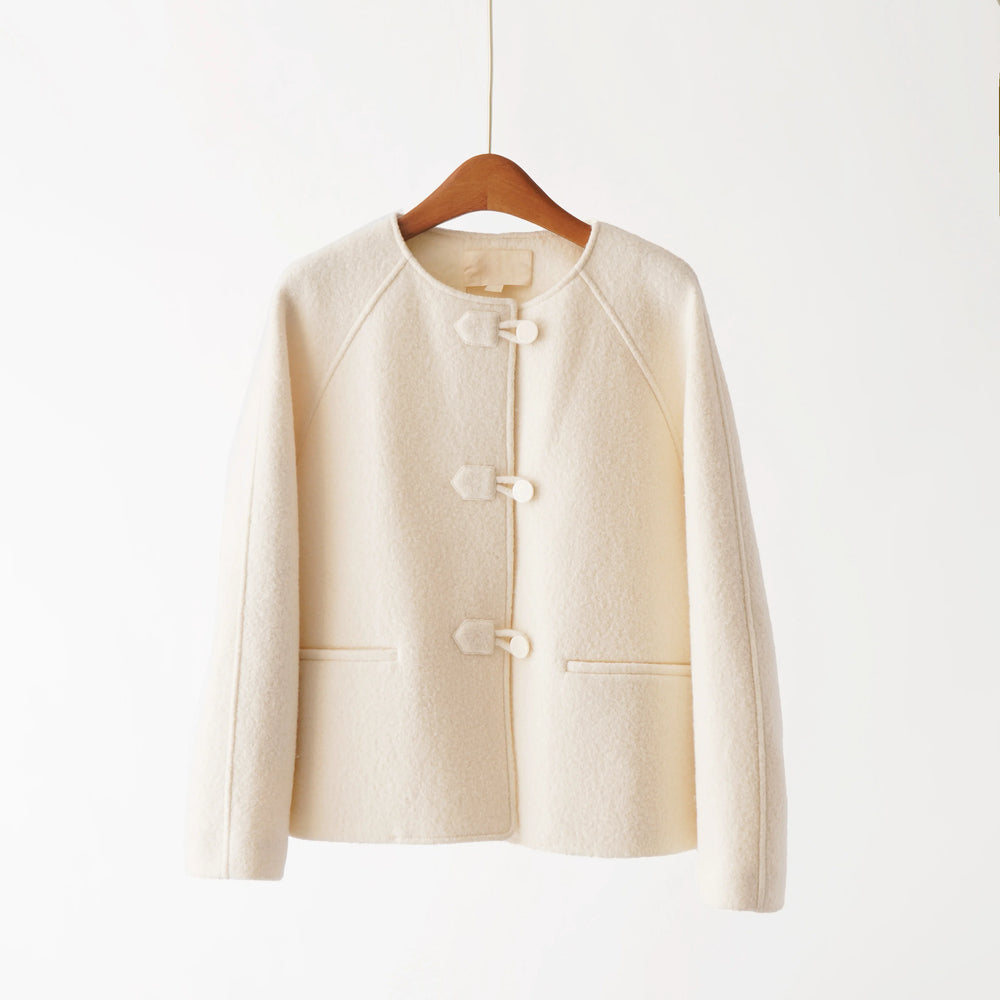 Beige jacket on a wooden hanger against a white background