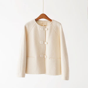 Beige jacket on a wooden hanger against a white background