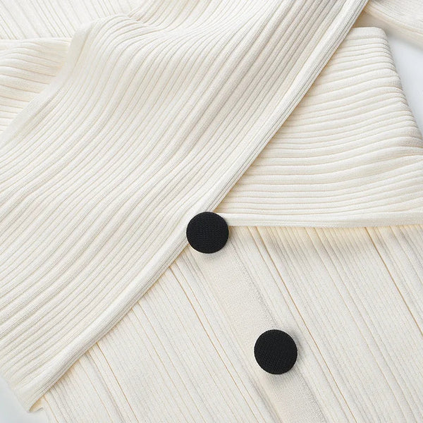 Close-up of a textured white fabric with black buttons on a light gray background