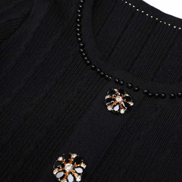 Black beaded necklace with floral pendants on a black background