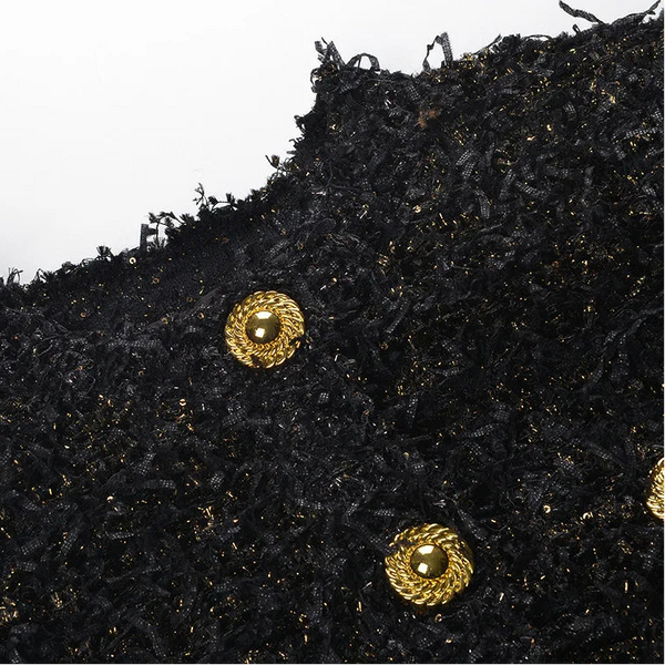 Black textured fabric with gold buttons on a white background