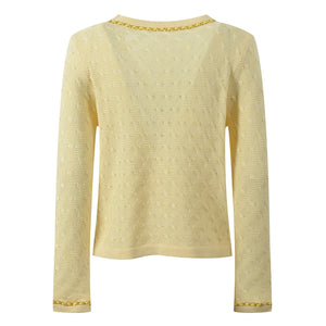Light yellow sweater with gold trim on a white background