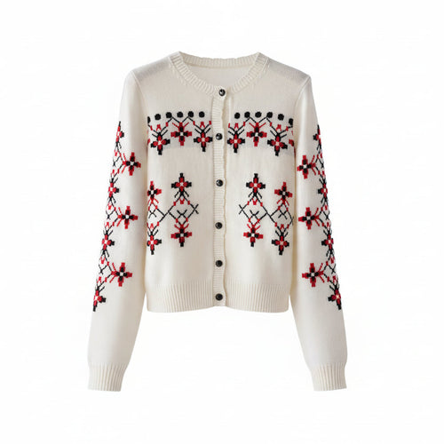 White sweater with red and black patterns on a wooden hanger against a white background