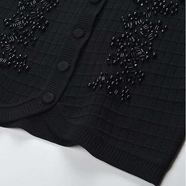 Black cardigan with bead embellishments on a white background