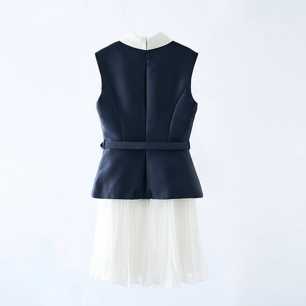 Navy blue sleeveless top with a white pleated skirt on a hanger against a light gray background