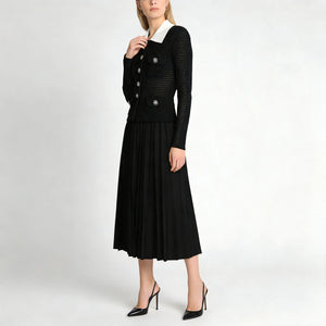Woman wearing a black dress with a white collar on a white background
