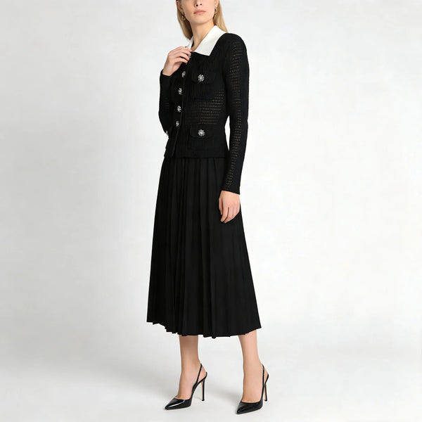 Woman wearing a black dress with a white collar on a white background