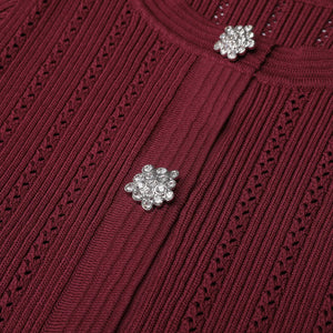Close-up of a burgundy sweater with decorative buttons.