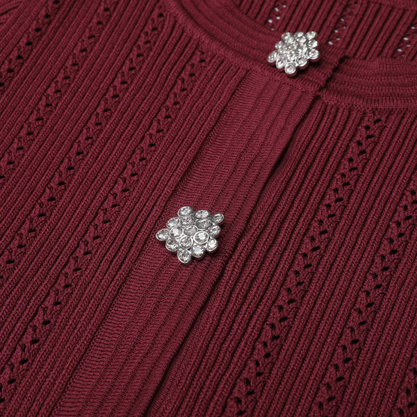 Close-up of a burgundy sweater with decorative buttons.