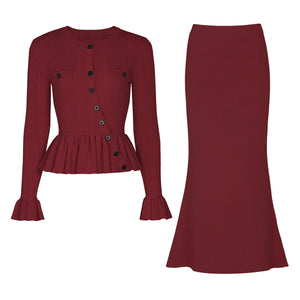 Red ribbed blouse with black buttons and a matching red skirt on a white background
